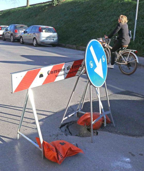 Una buca sull’asfalto in un punto pericoloso