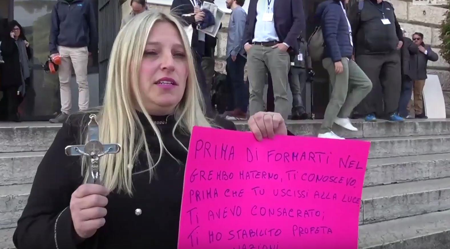 Samanta Nicoli, con il crocifisso e il cartello sulle scale del Palazzo della Gran Guardia poco prima di essere allontanata