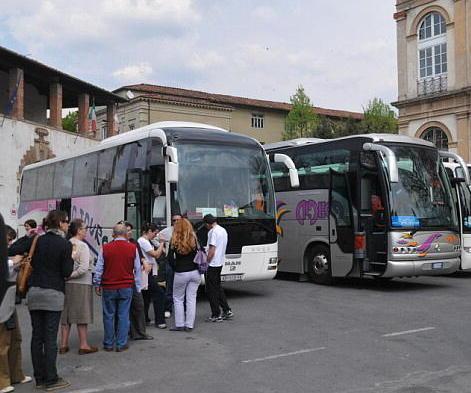 Turisti salgono sui bus turistici parcheggiati in piazzale Verdi a Lucca (Foto Vip)