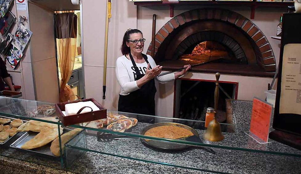 Una donna davanti al forno e l’idea del sacchetto mare per una pizza in spiaggia
