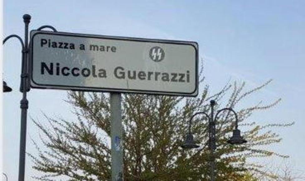 L'adesivo appiccicato sul cartello che indica il nome della piazza