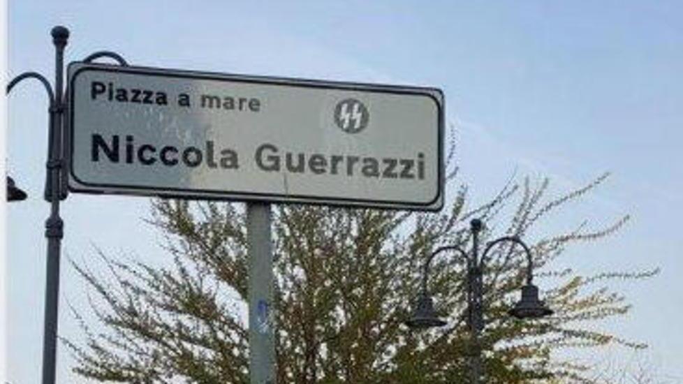 L'adesivo appiccicato sul cartello che indica il nome della piazza