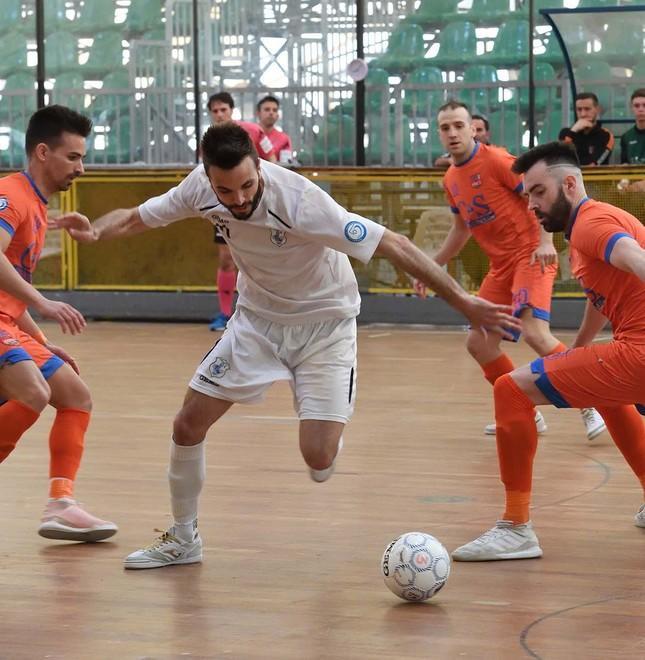 Il capocannoniere del Prato, Berti, fra tre avversari del Futsal Gisinti Pistoia Montecatini