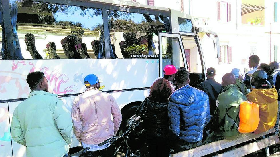 I profughi in attesa di salire su uno degli autobus per il trasferimento da Livorno a Piombino