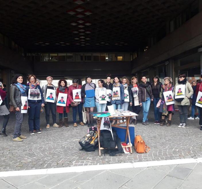 Femministe in sala consiliare con i cartelli degli insulti ricevuti