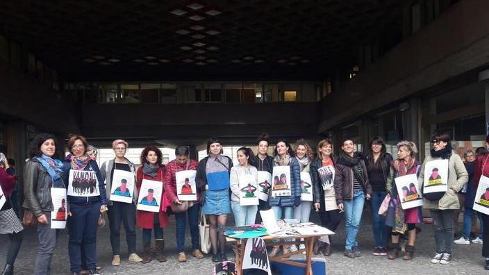 Femministe in sala consiliare con i cartelli degli insulti ricevuti