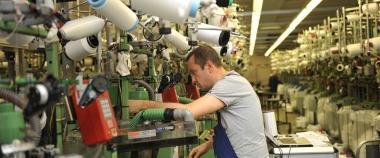Un operaio al lavoro su un macchinario tessile 