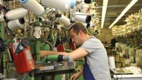 Un operaio al lavoro su un macchinario tessile