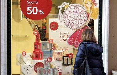 Una signora davanti a una vetrina con gli sconti 