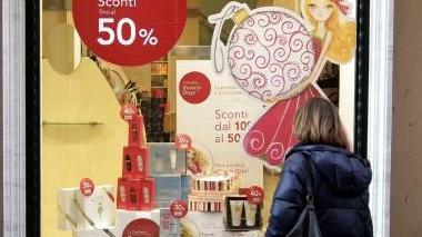 Una signora davanti a una vetrina con gli sconti