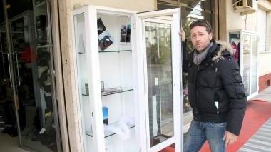 <b>FURTI.</b> Il proprietario del negozio Stagi mostra la vetrina infranta (Foto d’archivio)