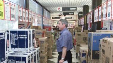 A destra, tecnici del computer al lavoro e a sinistra l’interno di un Computer Discount