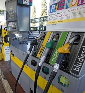Un motociclista mentre fa il pieno Sotto le pompe di carburante in una stazione di rifornimento  