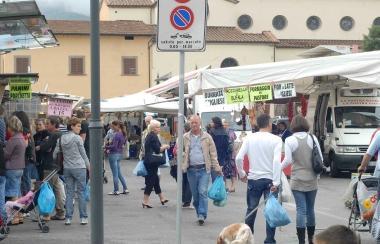 Clienti al mercato con le tradizionali borse di plastica in mano 
