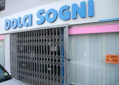 Il cancello del negozio in via della Pina doro chiuso da ieri In basso i sigilli della Finanza 