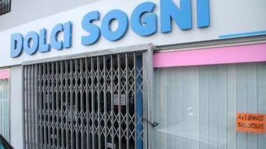 Il cancello del negozio in via della Pina d’oro chiuso da ieri In basso i sigilli della Finanza