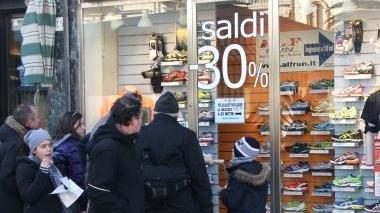 Due vetrine del centro che annunciano i saldi cominciati da due giorni
