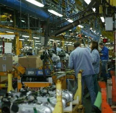 Dipendenti Piaggio alluscita dallo stabilimento Sopra operai al lavoro su una linea di produzione 