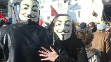 <b>LA PROTESTA AL PORTO MEDICEO.</b> Due manifestanti con la maschera-simbolo di Anonymous. A destra: uno degli striscioni-chiave: “Il mare non è una discarica”
