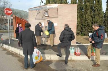 Un gruppo di persone fa scorta di acqua ad una fontanella pubblica