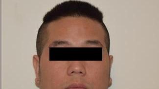 Il cinese arrestato col volto coperto nella foto fornita dalla polizia