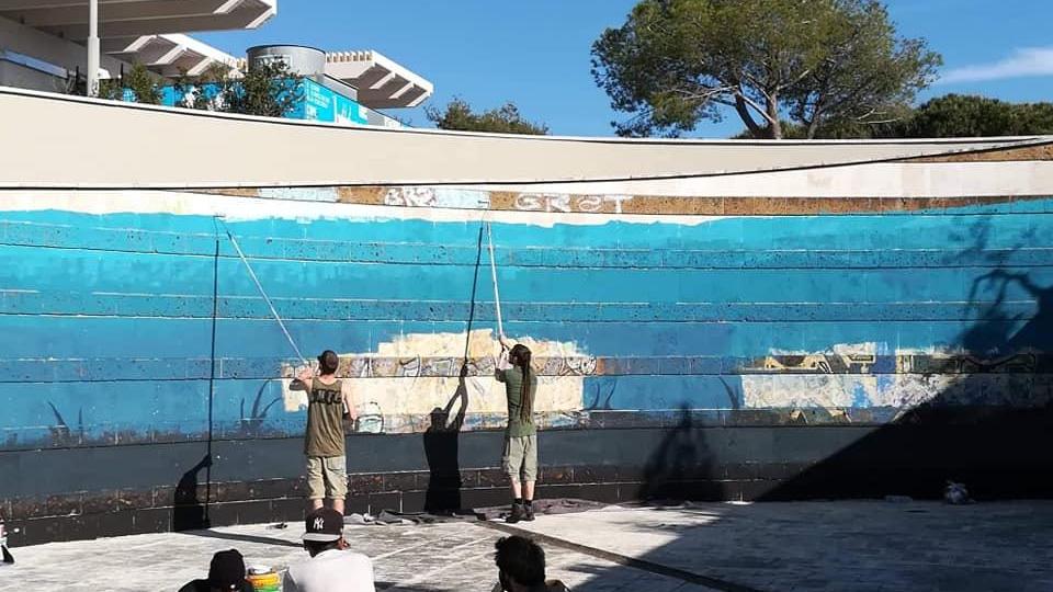 Street artist al lavoro nell'anfiteatro su via della Costituzione