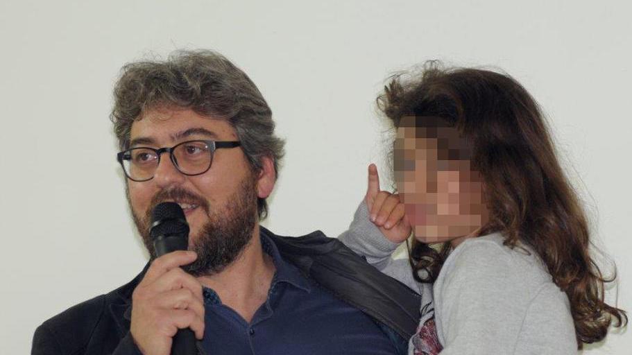 Il papà della piccola Giorgia Carli con in braccio la sorellina più grande (foto Giancarlo Grassi)