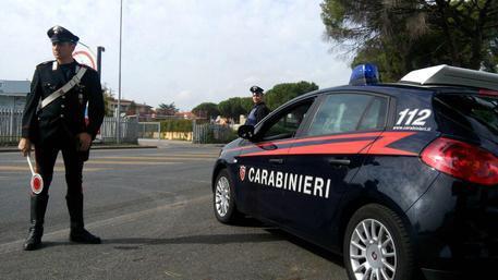 Tenta di strangolare il figlio e lo insegue con l'accetta