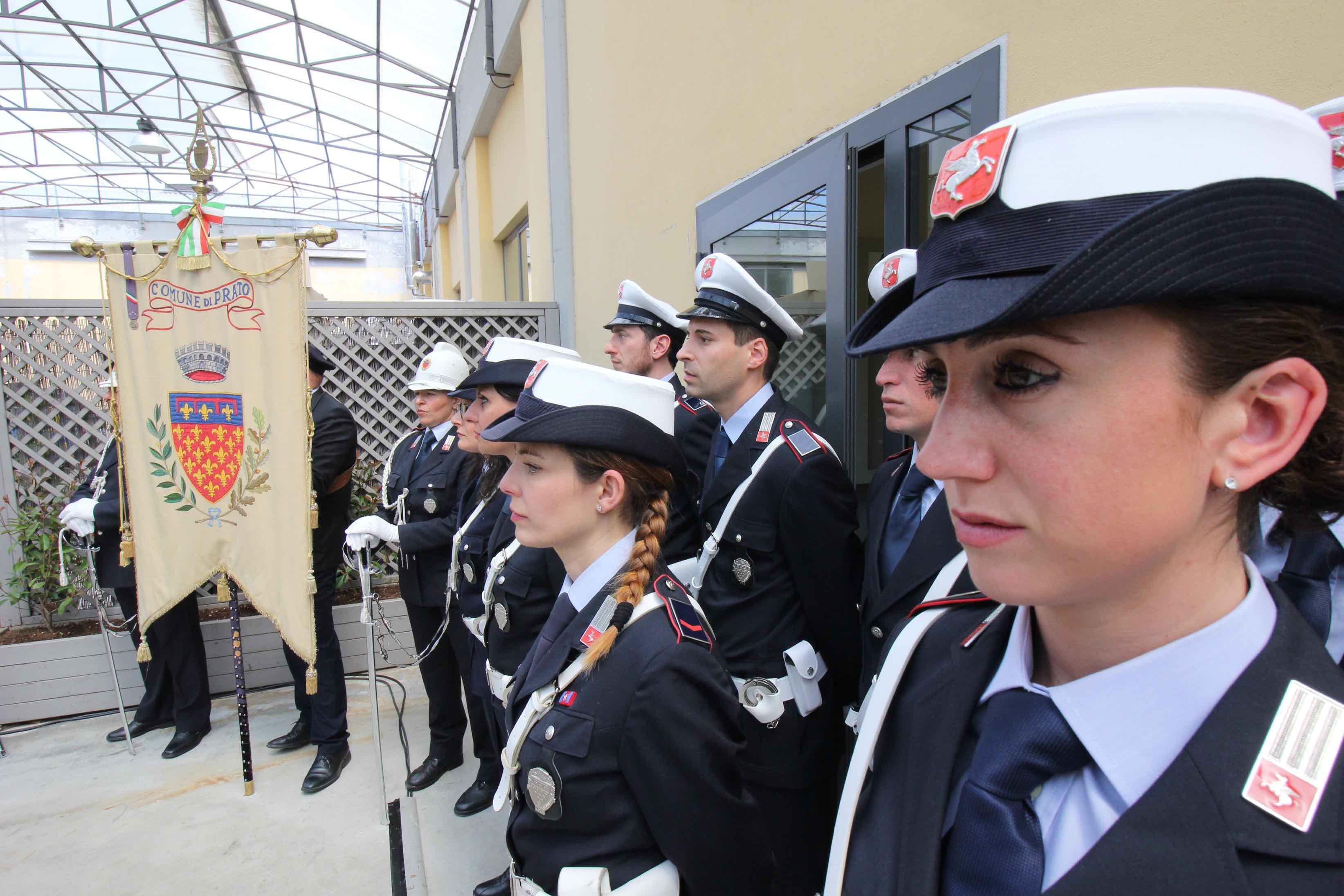 Agenti della Polizia municipale schierati accanto al gonfalone del Comune durante la festa del Corpo