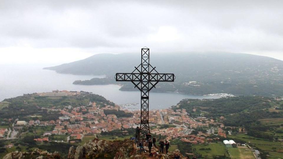La croce simbolo svetta di nuovo e domina Porto Azzurro