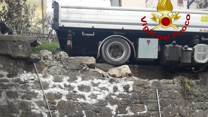 Nella foto dei vigili del fuoco l'autocarro in bilico sopra al giardino della casa