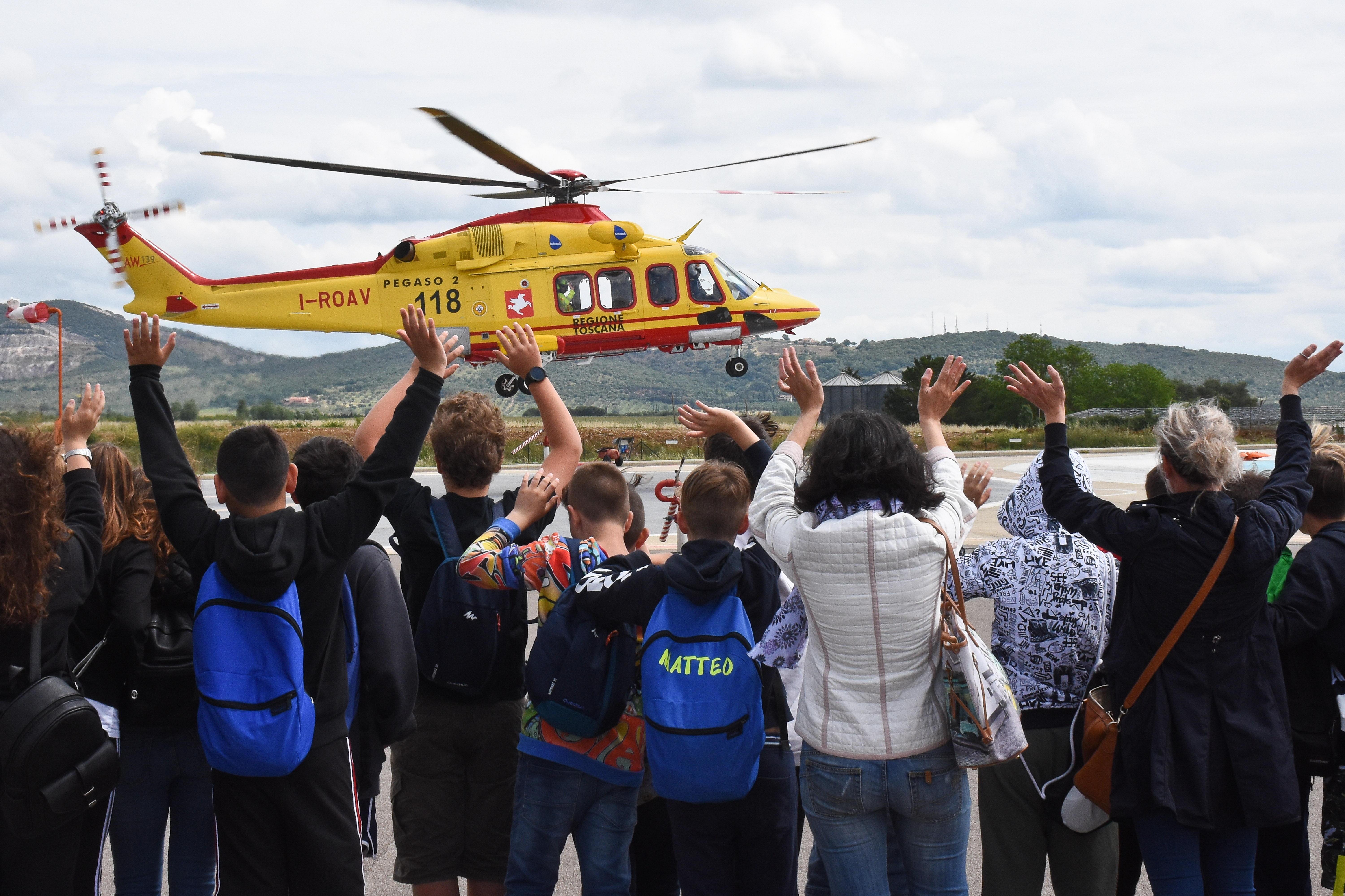 Le scolaresche salutano l'elicottero di soccorso sanitario Pegaso 2 mentre si alza in volo dalla piazzola dell'ospedale Misericordia di Grosseto (foto Agenzia Bf)