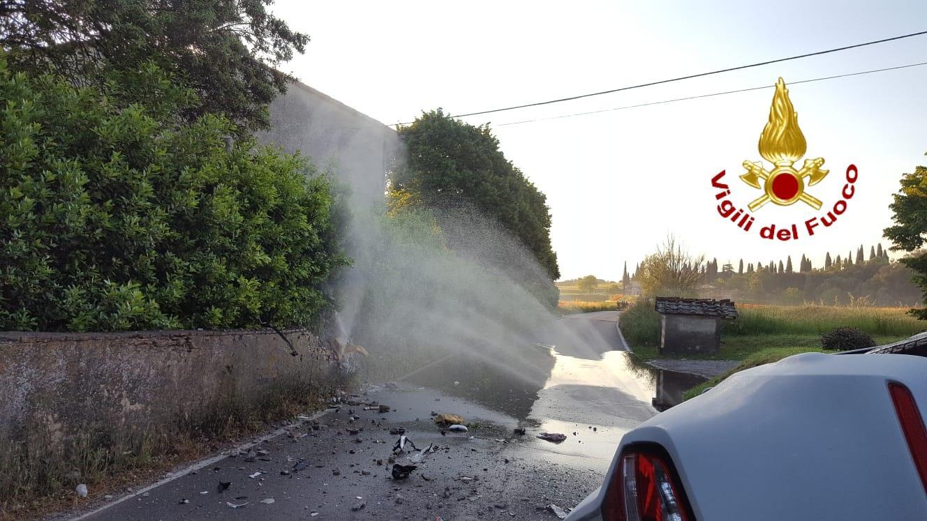 Nella foto dei vigili del fuoco l'auto ribaltata e il gas che esce dal tubo rotto