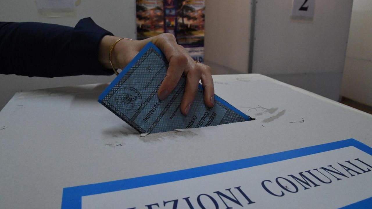 Una scheda nell'urna durante le elezioni amministrative