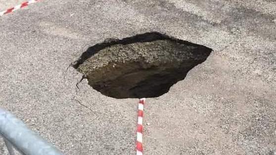 Profonda buca in strada La causa un tubo rotto