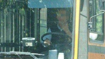La fotografia scattata con il teleobiettivo riprende un autista del Ctm mentre sta armeggiando col telefonino (foto Rosas)    