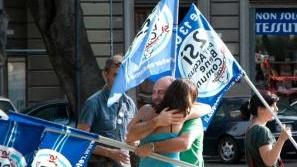 Abbracci in piazza a Cagliari (a sinistra) e Sassari
