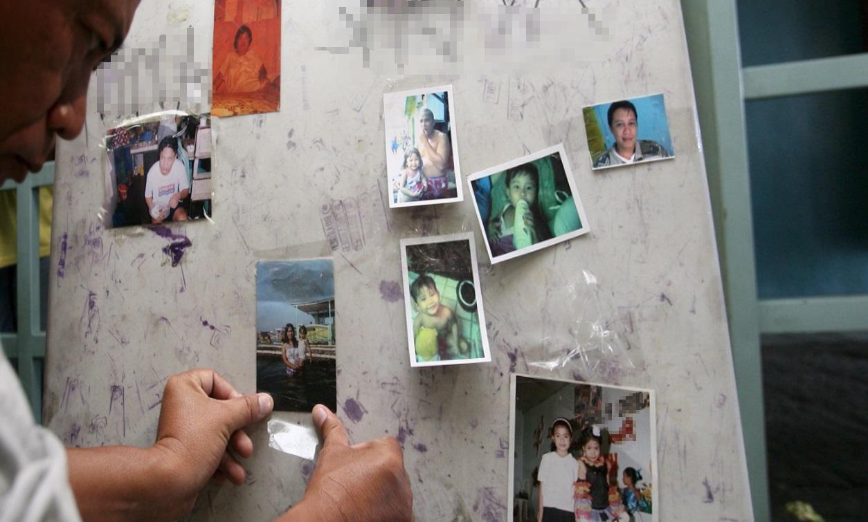 Un marittimo straniero lontano da casa mette le foto dei familiari su una bacheca