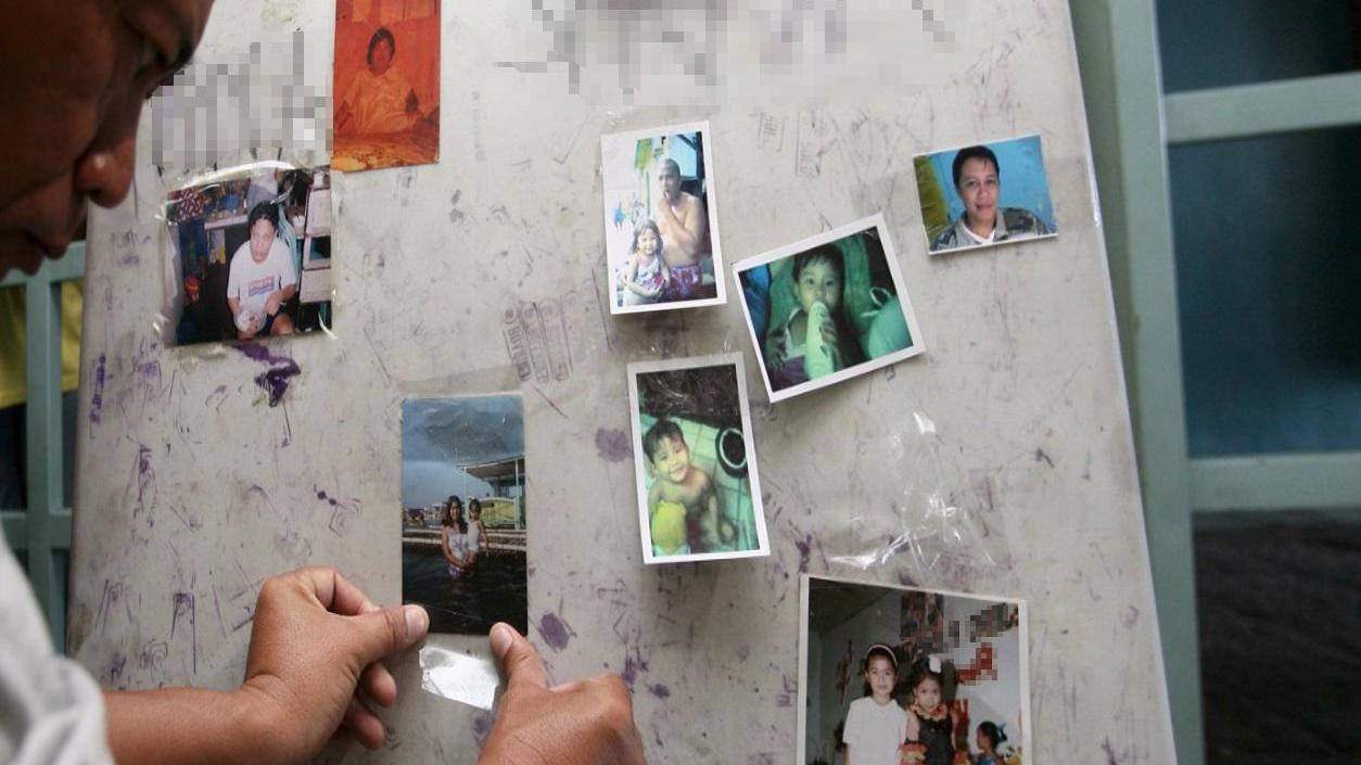 Un marittimo straniero lontano da casa mette le foto dei familiari su una bacheca