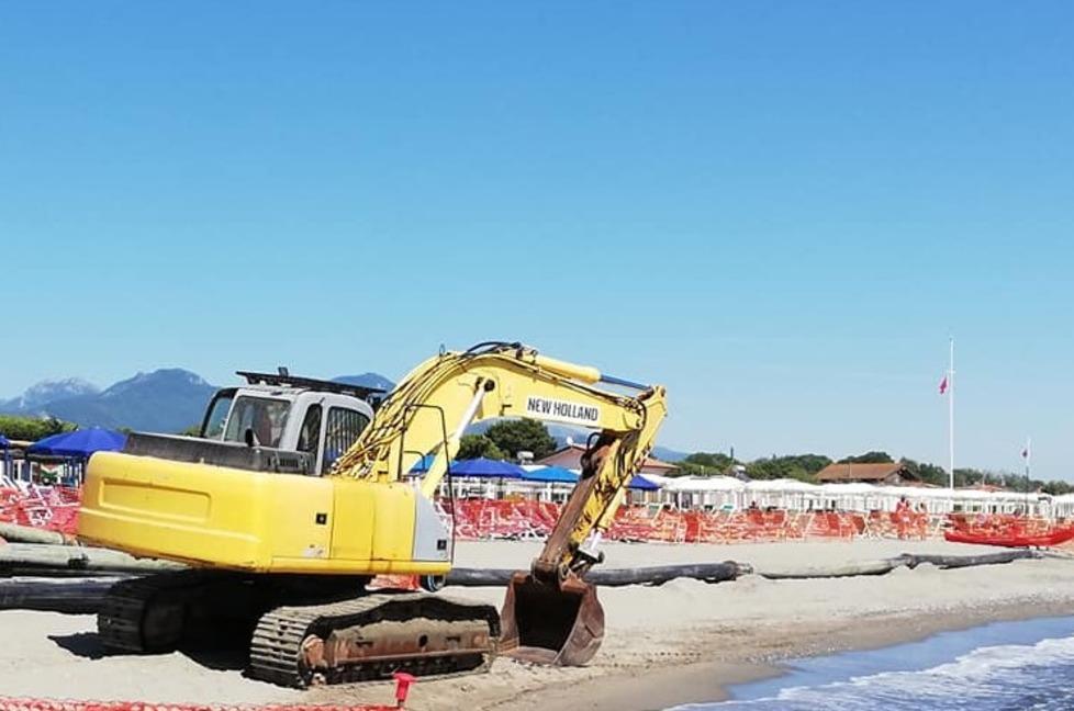 Sabbia al largo, va riportata sulla riva. E le ruspe lavorano tra gli ombrelloni 