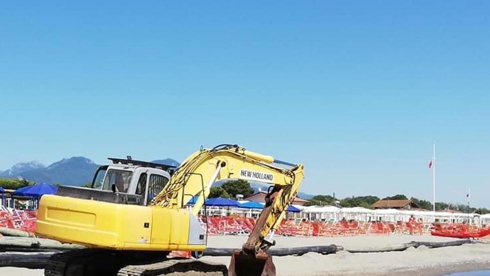 Sabbia al largo, va riportata sulla riva. E le ruspe lavorano tra gli ombrelloni
