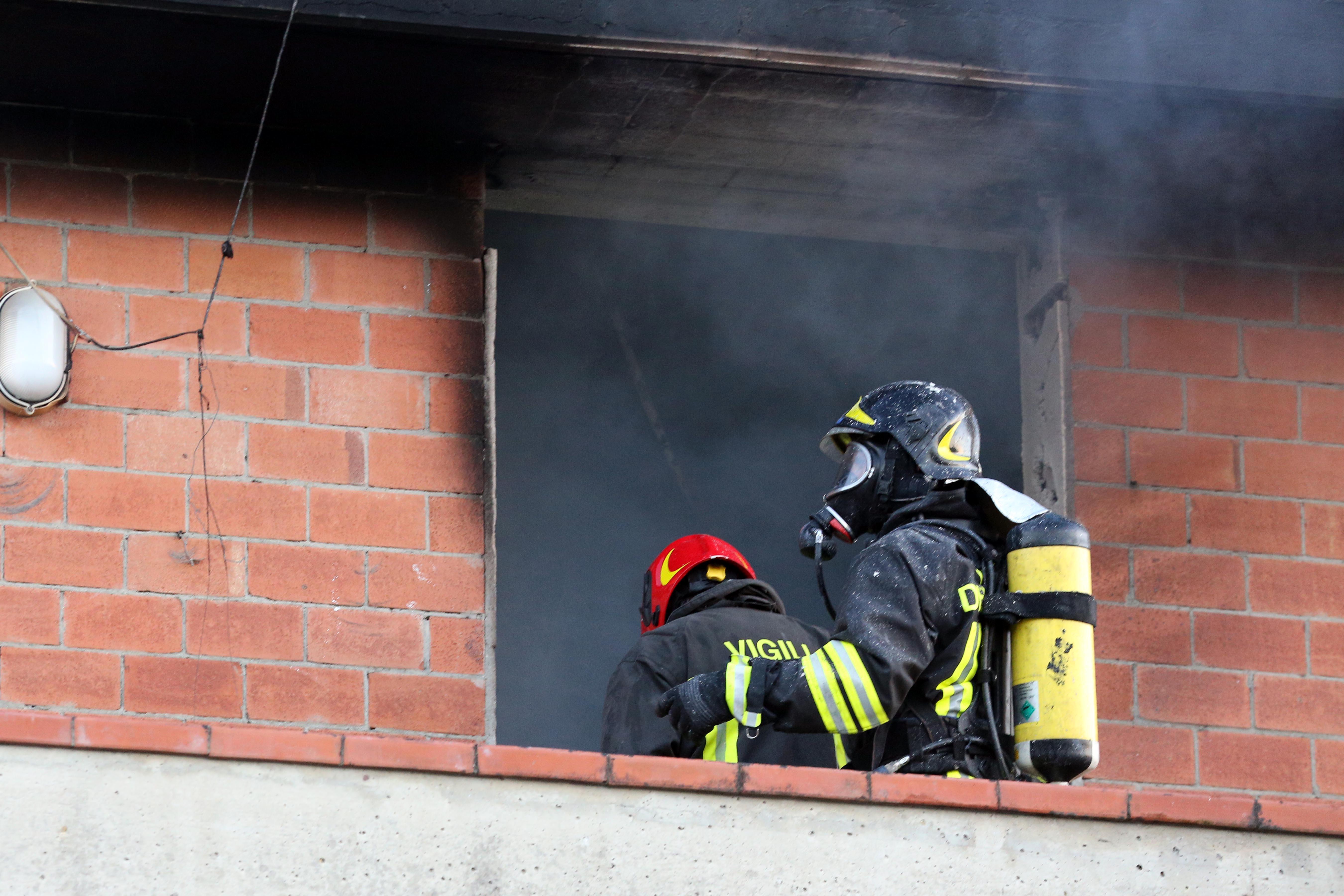 I vigili del fuoco sul terrazzo della palazzina da cui fuoriesce il fumo