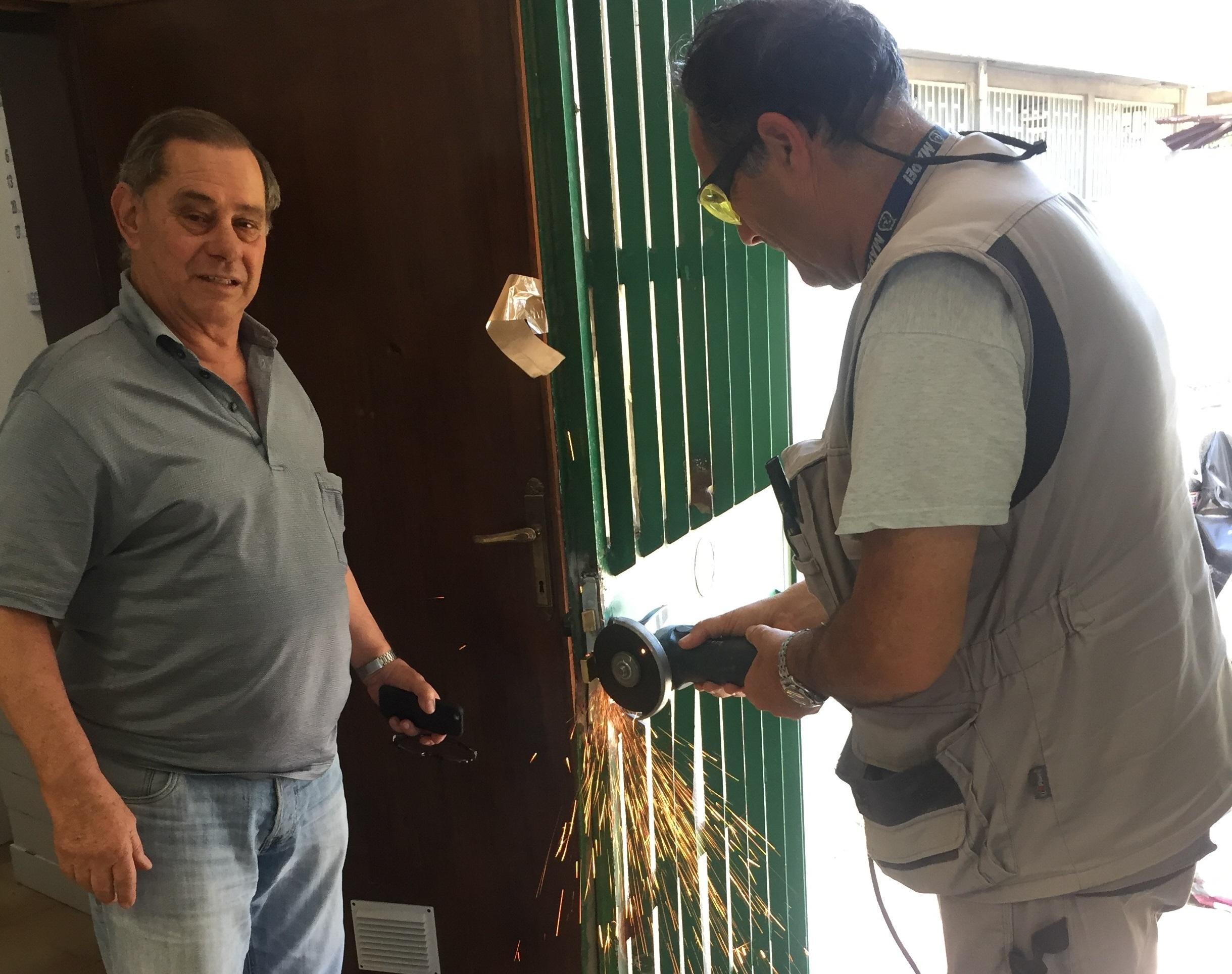 Bruno Veroni con un operaio che ripara l'ingresso