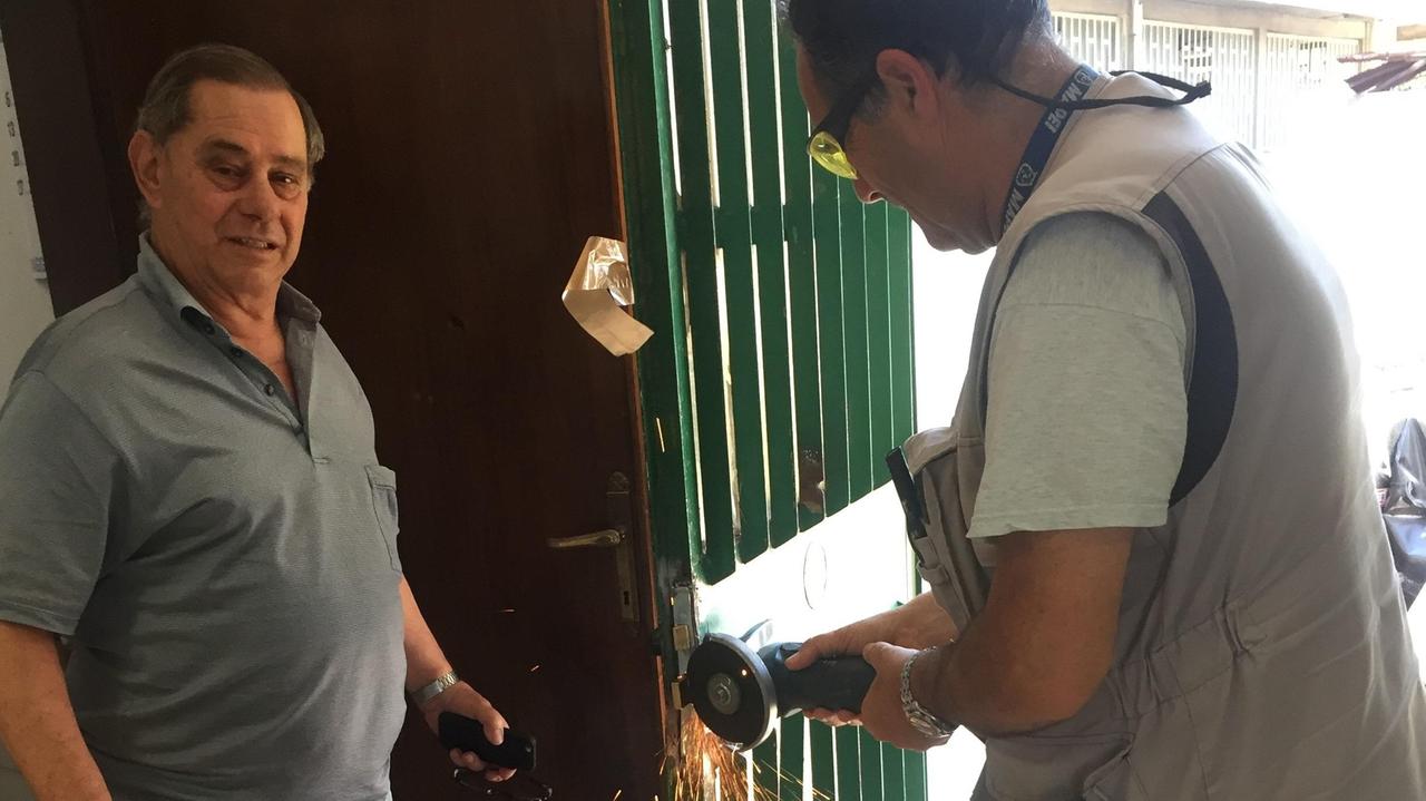 Bruno Veroni con un operaio che ripara l'ingresso