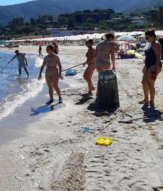 Volontari puliscono la spiaggia