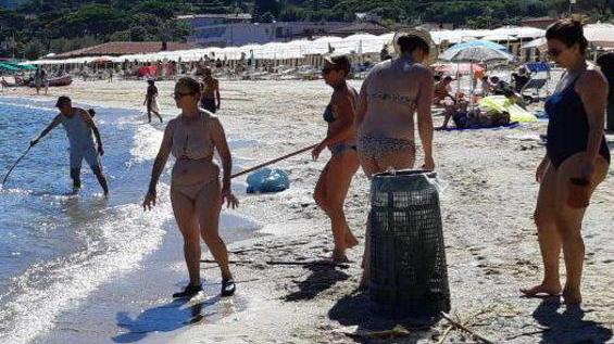 Volontari puliscono la spiaggia