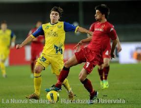 Paloschi con la maglia del Chievo contrastato da Ariaudo