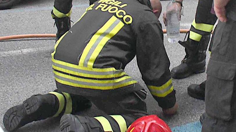 Il vigile del fuoco in ginocchio e la bottiglia d’acqua del collega