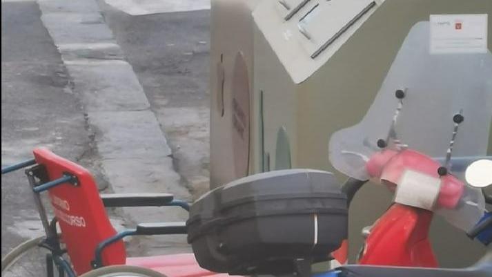 Una sedia a rotelle del pronto soccorso abbandonata accanto al cassonetto Aamps della differenziata in via delle Galere