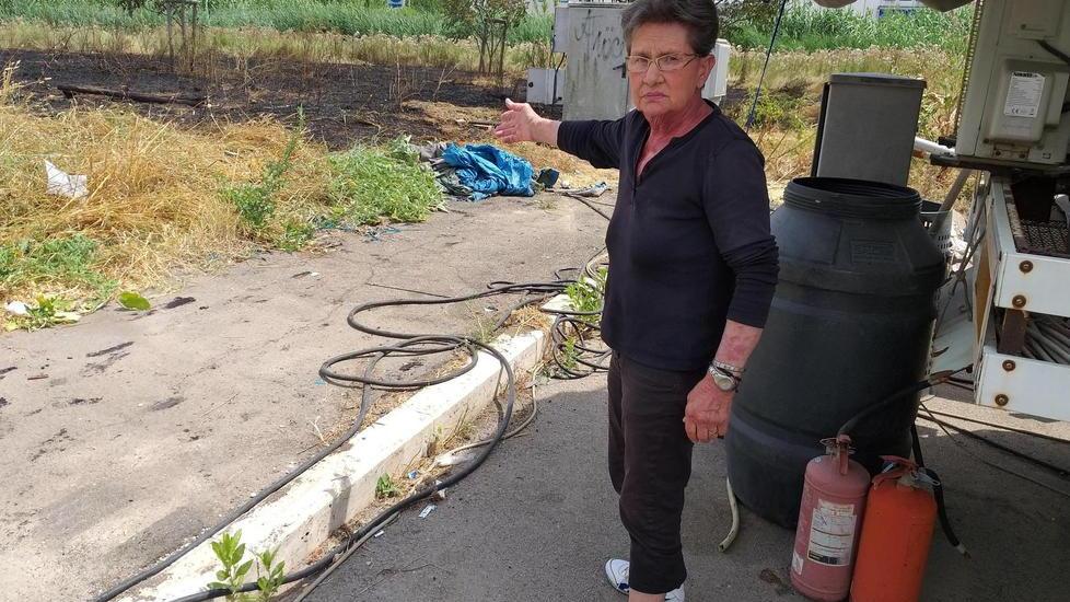 Mary Falorni indica la roulotte accanto all'incendio
